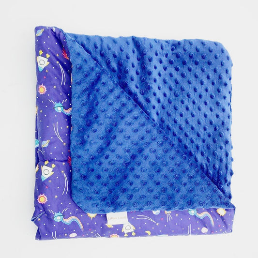 Rocketman toddler blanket, folded to show the patterned cotton and navy minky sides
