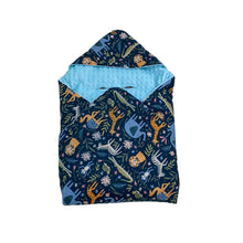 Load image into Gallery viewer, Blue Safari Animals car seat blanket for a 5-point harness, patterned side out, folded with the light blue minky hood
