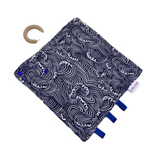 Load image into Gallery viewer, Waves taggie, patterned cotton side with ribbon tags and a wooden ring