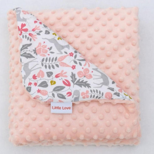 Little Deer toddler blanket, folded to show the patterned cotton and peach minky sides